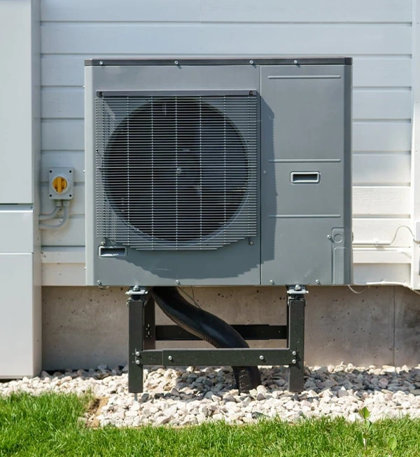 Outdoor unit of an air source heat pump system mounted on a stand.